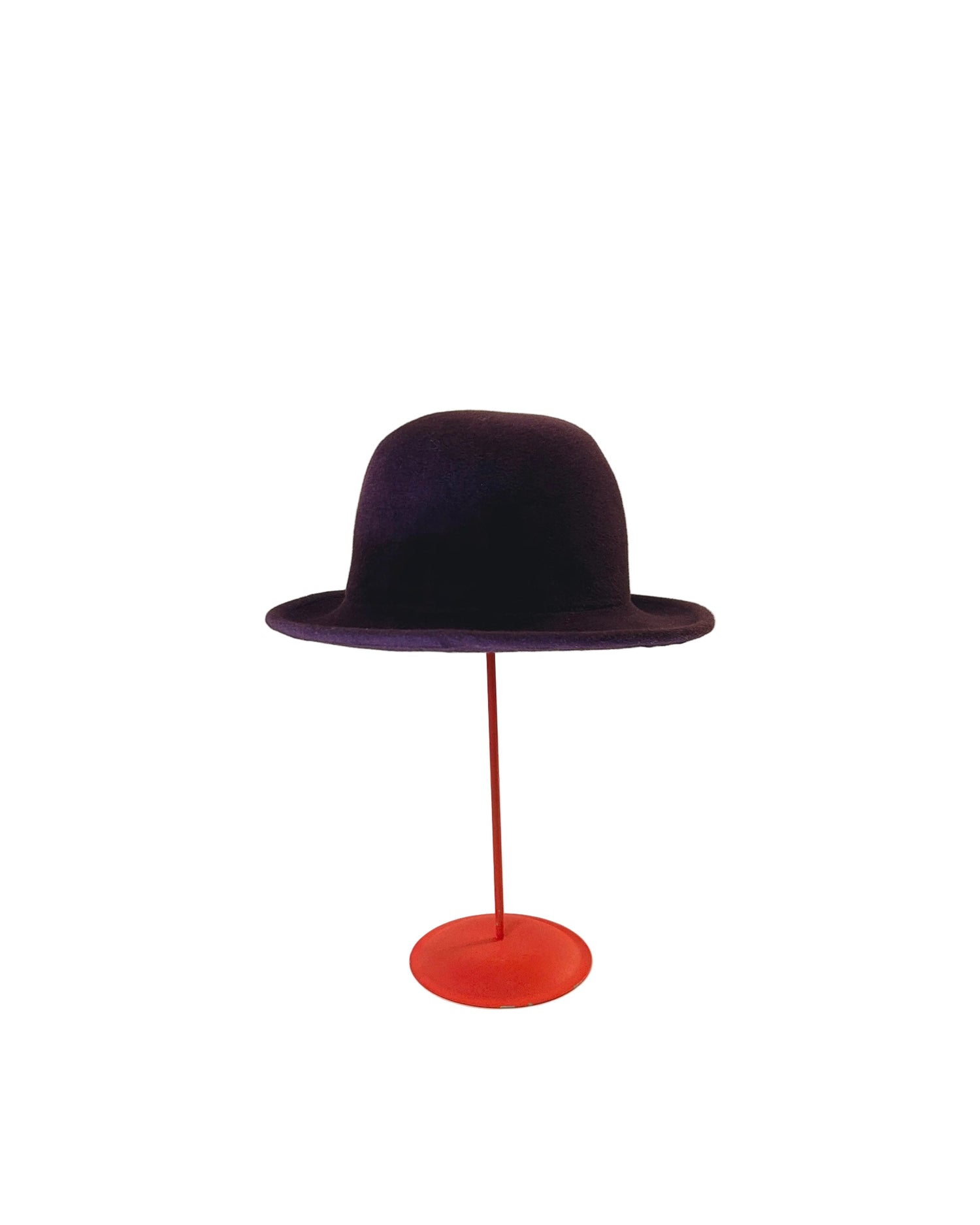 Purple Bowler hat on a red stand against a white background