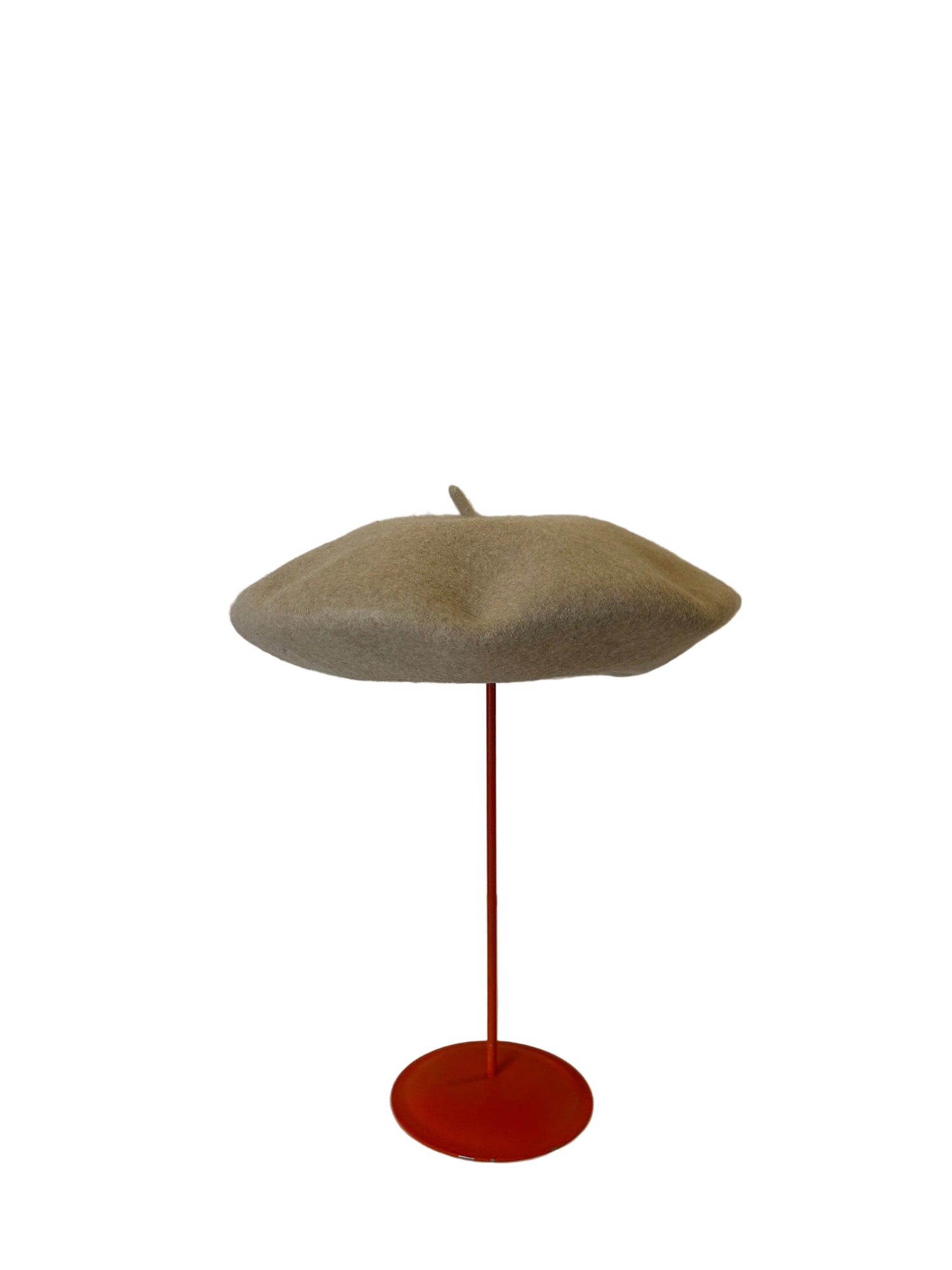 Beige Beret on a red stand against a white background