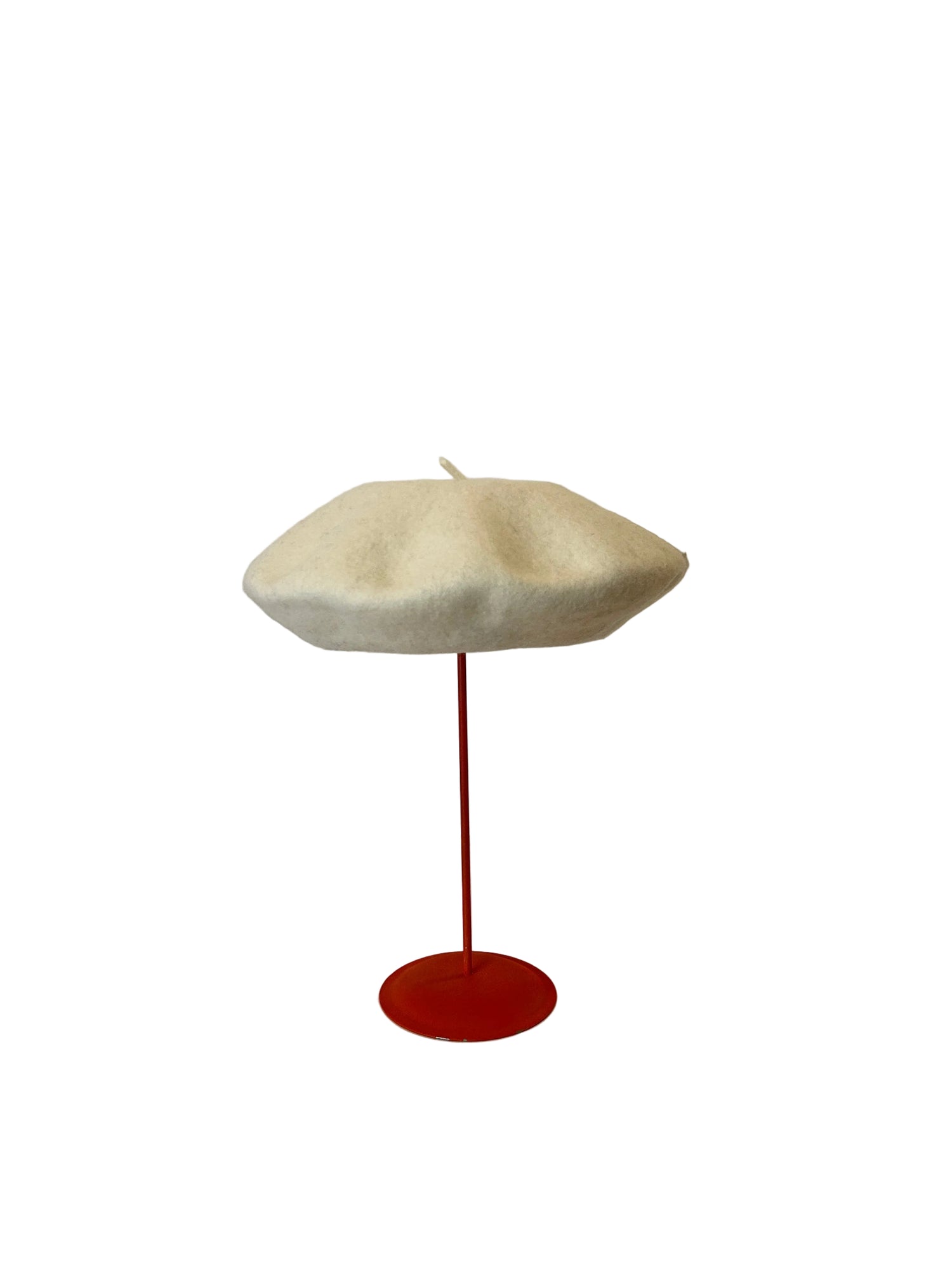 White Beret on a red stand against a white background