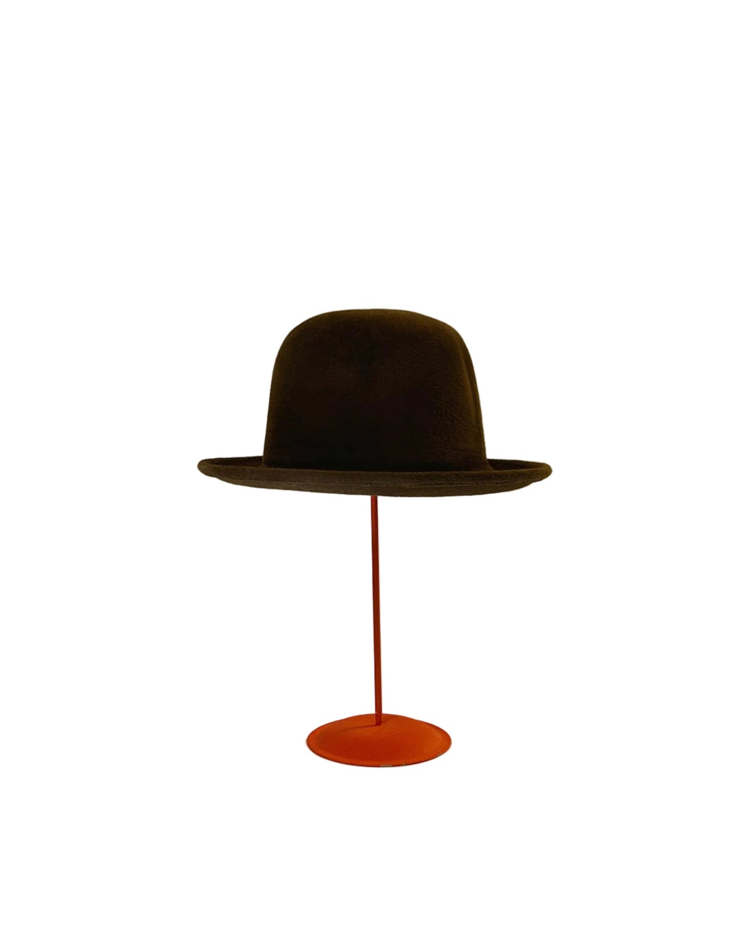 Brown Bowler hat on a red stand against a white background