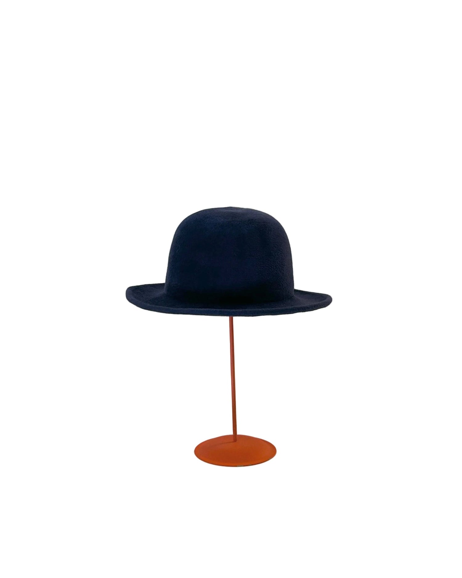 Navy blue Bowler hat on an red stand against a white background