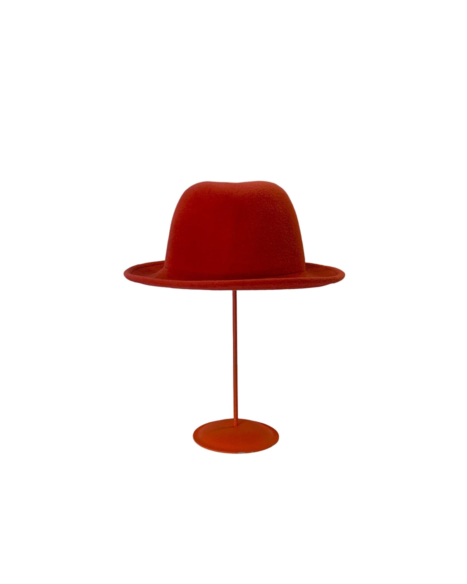 Red Bowler hat on a stand against a white background