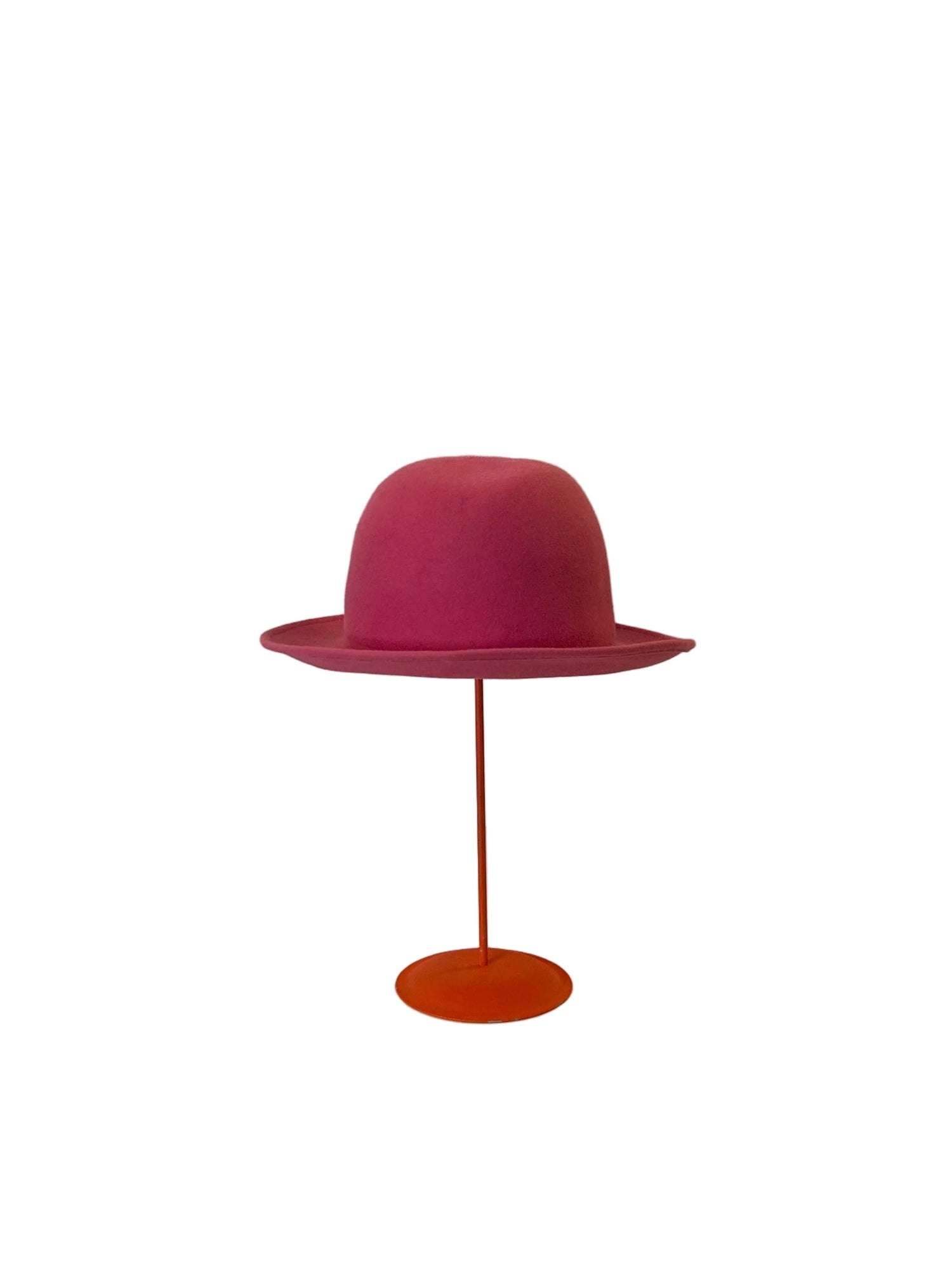 Pink Bowler hat on a stand against a white background