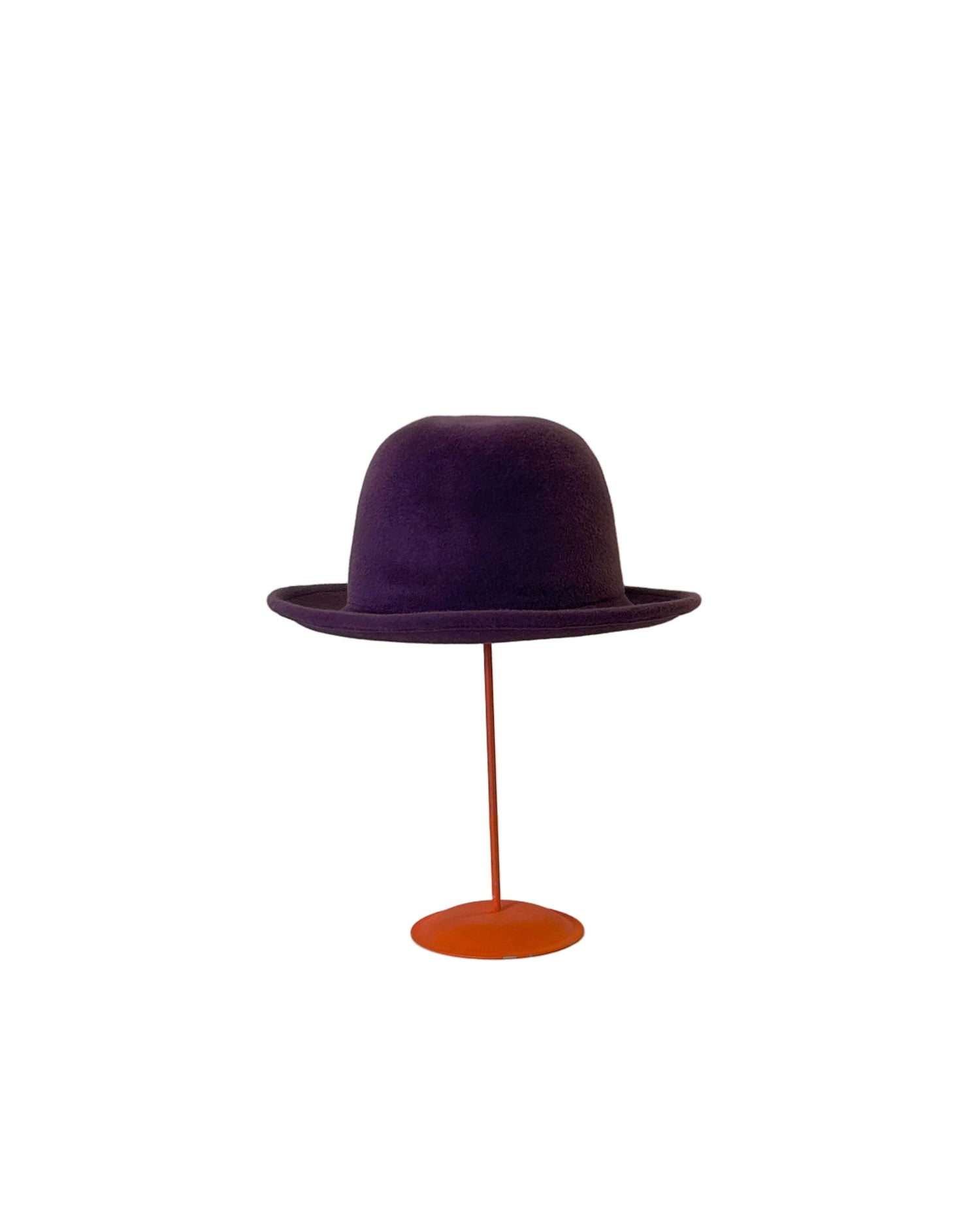 Purple Bowler hat on a red stand against a white background