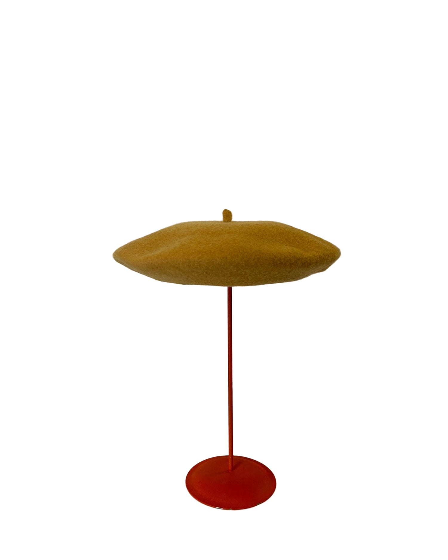 Yellow Beret on a red stand against a white background