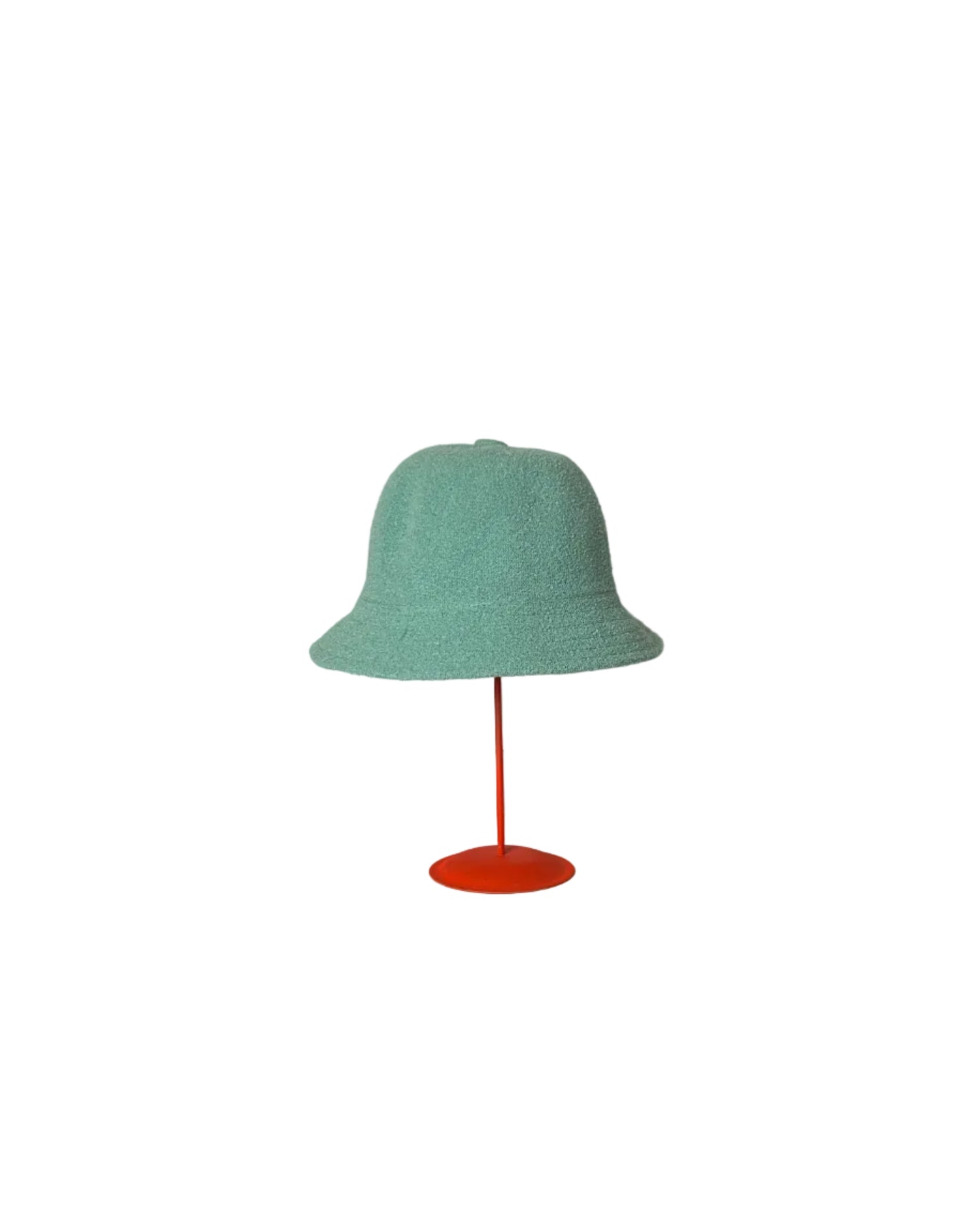 Turquoise Bucket hat on a red stand against a white backdrop. 
